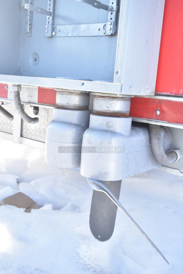 Rock Solid Cargo trailer undercarriage detail in snow, showing drainage pipes and metal framework.