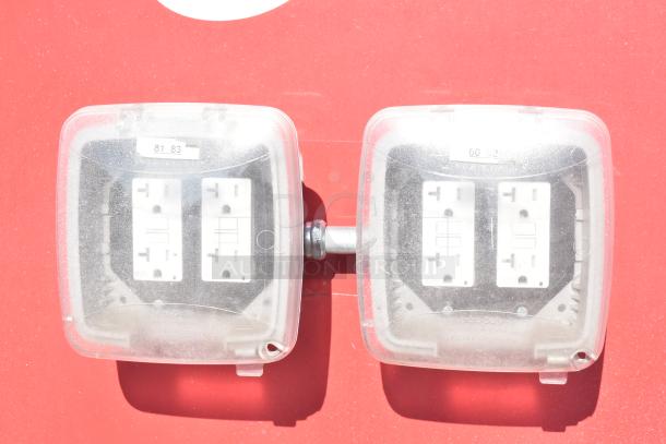 Electrical outlets with protective covers on red surface, marked with numbers "81 83" and "60 62".