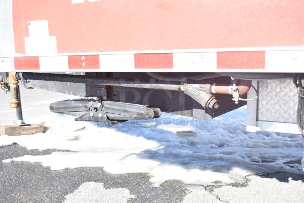 Rock Solid Cargo fast food trailer undercarriage with rusted hitch components on snowy ground.
