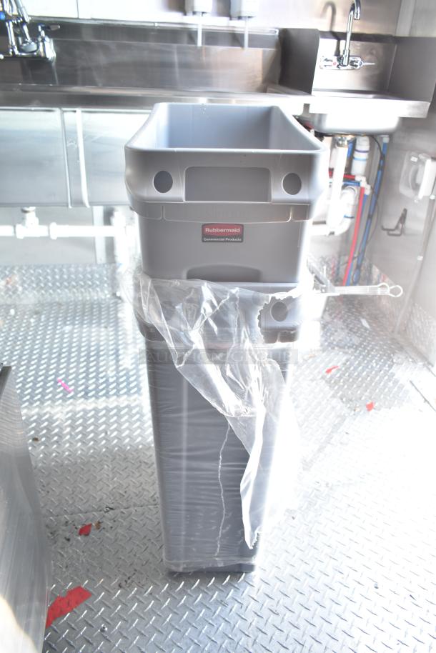 Rock Solid Cargo fast food trailer interior with Rubbermaid bin, stainless steel sink, and commercial kitchen fittings.