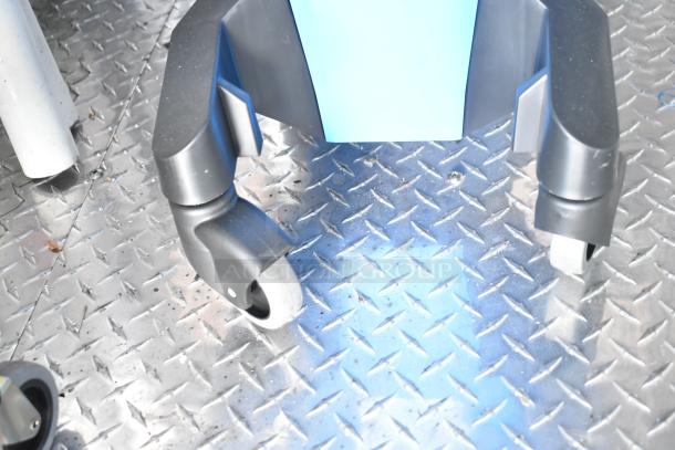 Black heavy-duty caster wheels on diamond-plated metal flooring inside a mobile fast-food kitchen trailer.