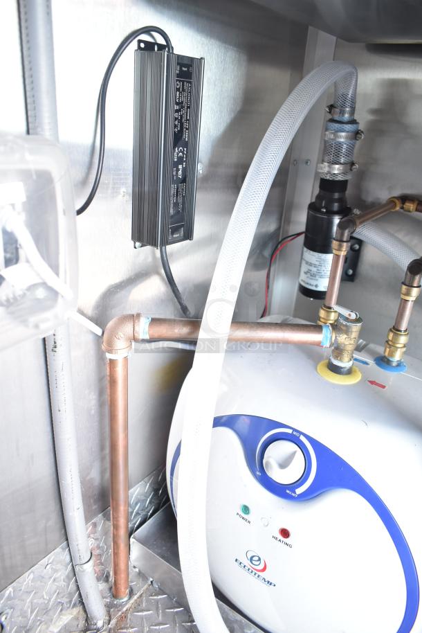 Inside view of a Rock Solid Cargo fast-food trailer showing copper piping, an EcoTemp water heater, and wiring system.