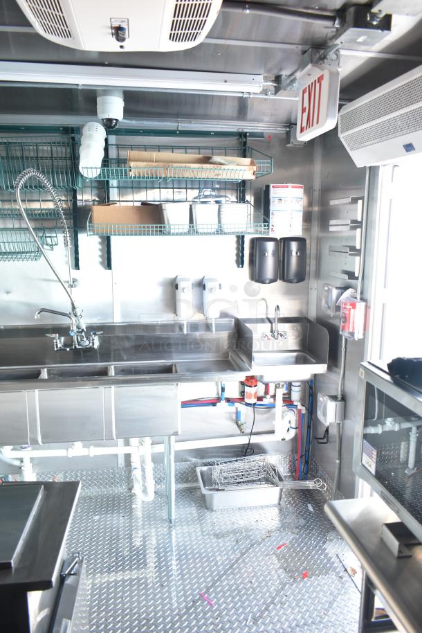 Rock Solid Cargo fast food trailer kitchen interior, featuring stainless steel sinks, shelving, and essential equipment.