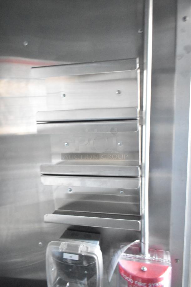 Interior view of Rock Solid Cargo fast food trailer showcasing stainless steel shelving and safety equipment, ideal for Wendy's-style operation.