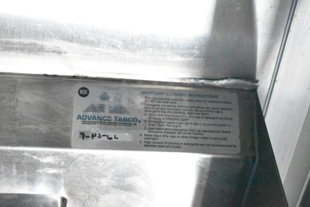 Advance Tabco cleaning instructions label on metal surface; includes guidelines for proper maintenance of stainless steel sinks.