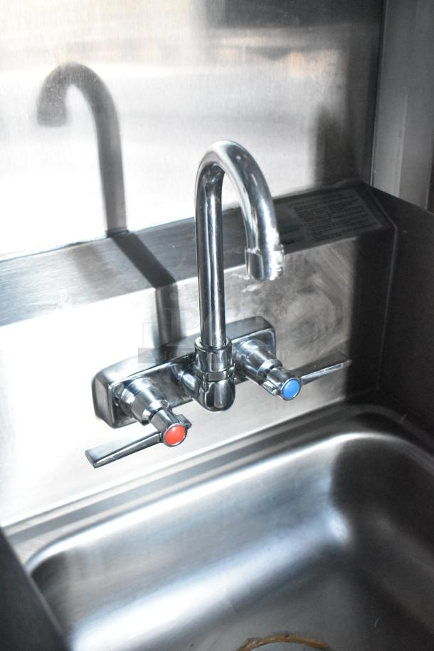 Stainless steel sink with dual-handle faucet in Rock Solid Cargo fast food trailer kitchen.