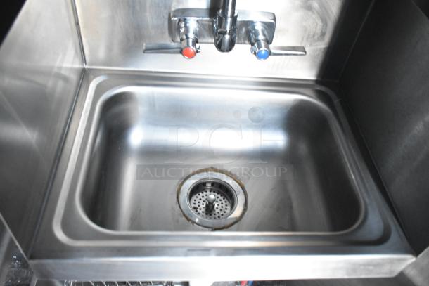 Stainless steel commercial kitchen sink with hot and cold taps, part of the Rock Solid Cargo mobile kitchen trailer.
