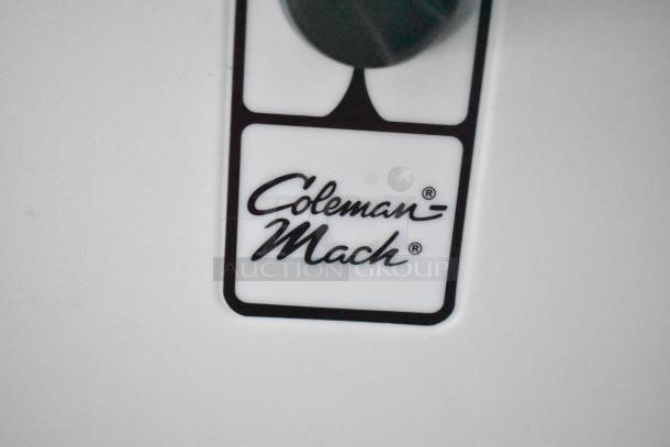 Coleman-Mach logo label on a surface, featuring bold black script on a white background.