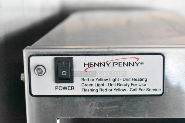 Henny Penny gas fryer power switch with operational lights indicator, part of a fully equipped fast-food trailer kitchen.