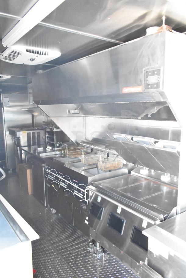 Rock Solid Cargo fast food trailer kitchen; features CaptiveAire hood, fryers, refrigeration, and stainless fixtures. New condition.