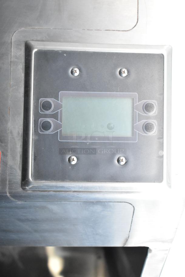 Control panel of the Rock Solid Cargo fast food trailer, featuring a digital display with buttons and screws, part of the mobile kitchen setup.