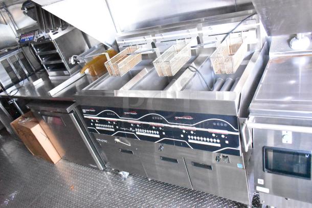 Rock Solid Cargo fast food trailer interior with Henny Penny gas fryer, stainless steel counters, and commercial-grade kitchen equipment.