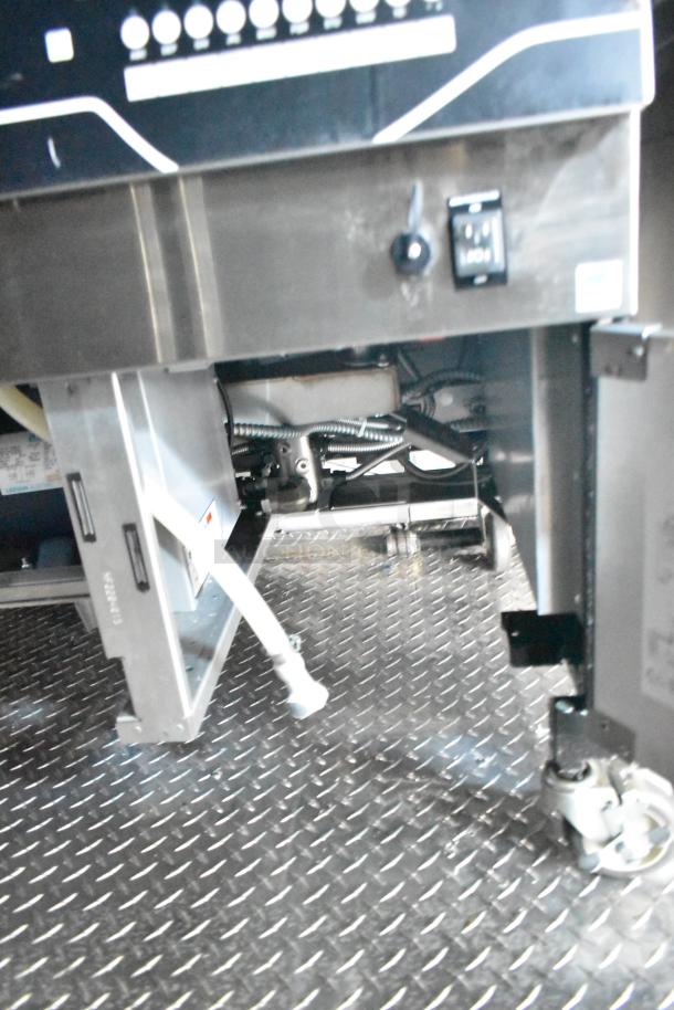 Rock Solid Cargo mobile kitchen interior with diamond plate flooring, showing part of commercial equipment setup.