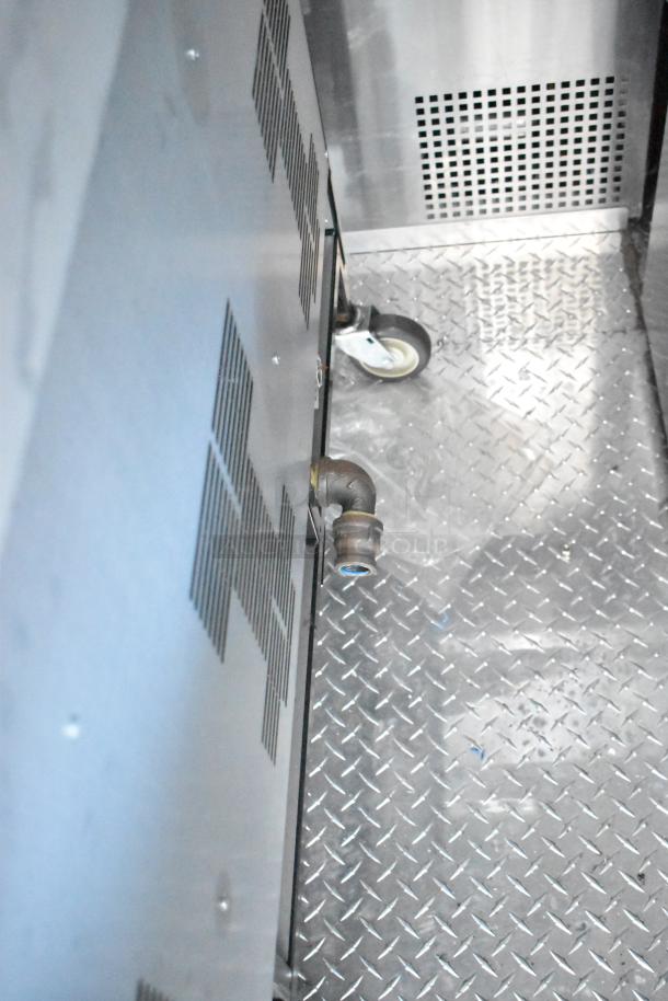 Rock Solid Cargo fast food trailer interior with metal flooring, visible pipe, and caster wheel. New condition.