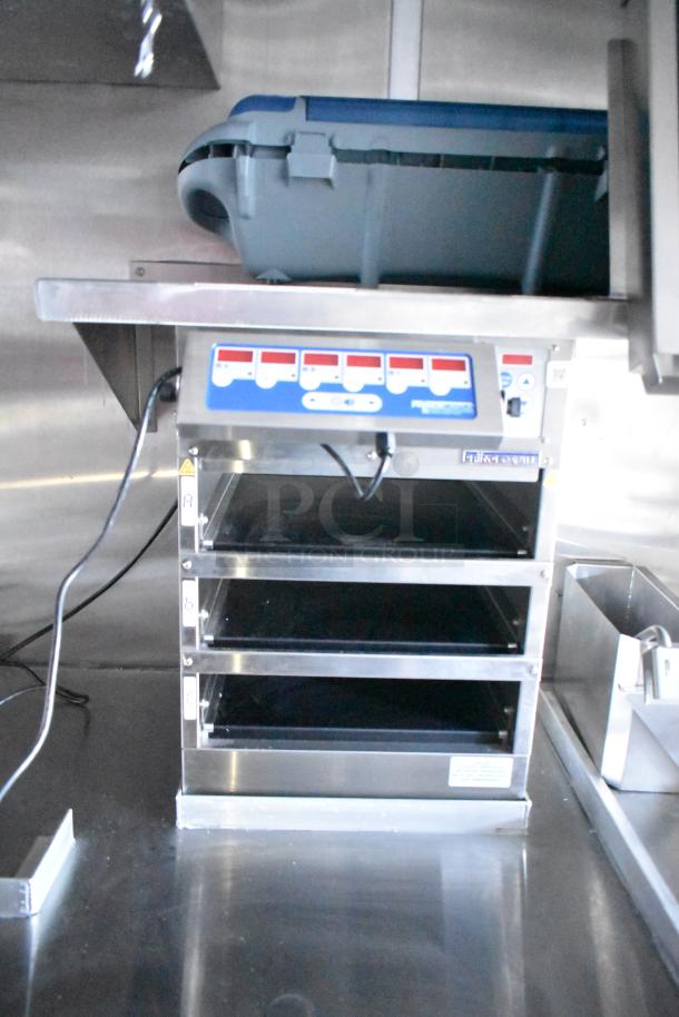 Rock Solid Cargo fast food trailer appliance, featuring a commercial-grade four-tier warmer with control panel in stainless steel.