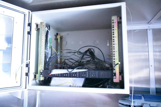 Electrical panel inside Rock Solid Cargo mobile kitchen trailer, featuring organized wiring and power outlets, part of fully outfitted fast-food setup.