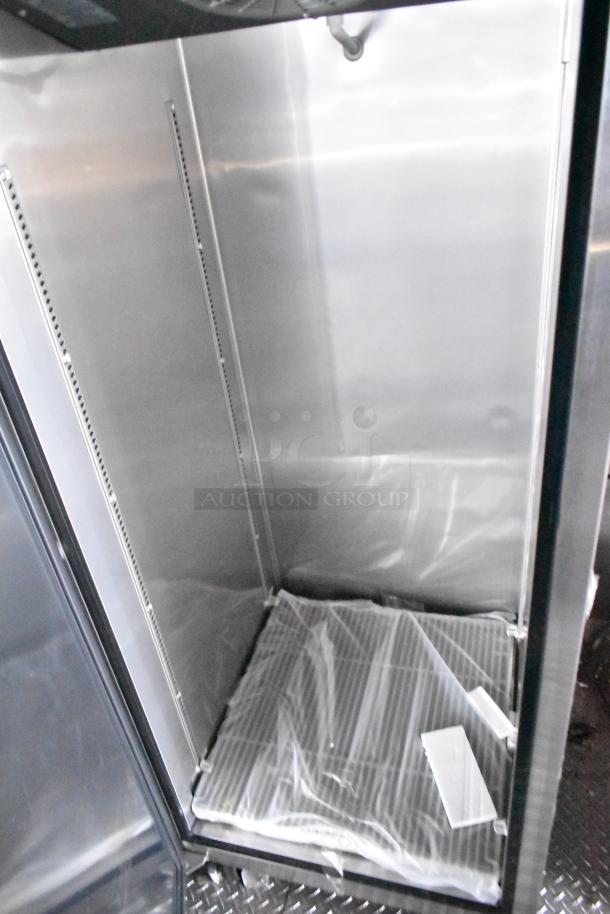 Interior of Rock Solid Cargo fast-food trailer, featuring a clean, stainless steel commercial refrigeration unit.