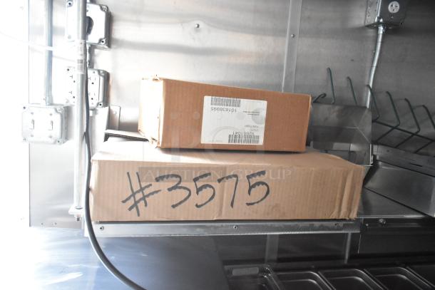 Cardboard boxes labeled "#3575" and "Foam Pump," inside a Rock Solid Cargo fast food trailer.
