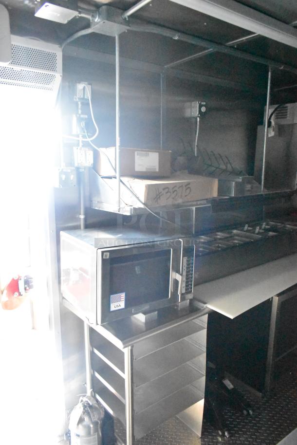 Rock Solid Cargo fast food trailer interior, featuring a microwave, shelving, and labeled box marked #3575.