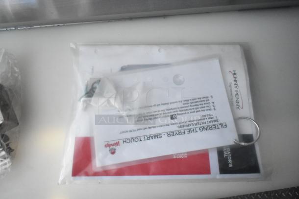 Plastic bag containing Wendy's branded documents and Henny Penny manuals for a fast food trailer.