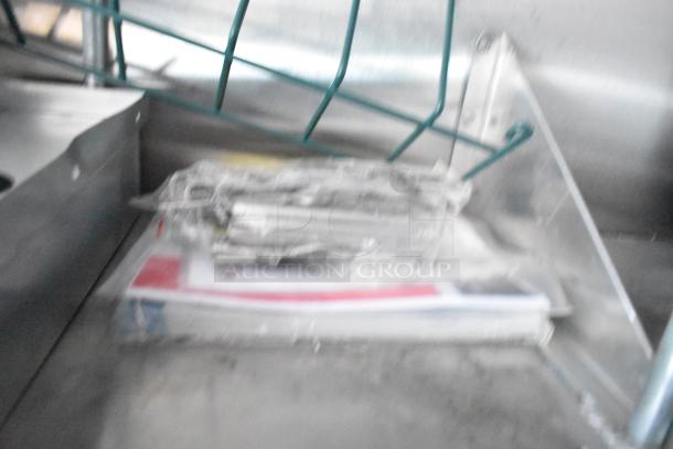 Blurry interior view of a mobile kitchen trailer with metal shelving and wrapped items.