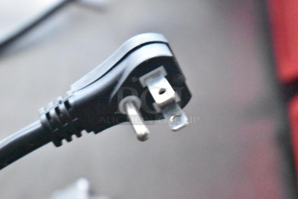 A close-up of a three-prong power plug, with a black casing, possibly for use with the described commercial-grade systems.