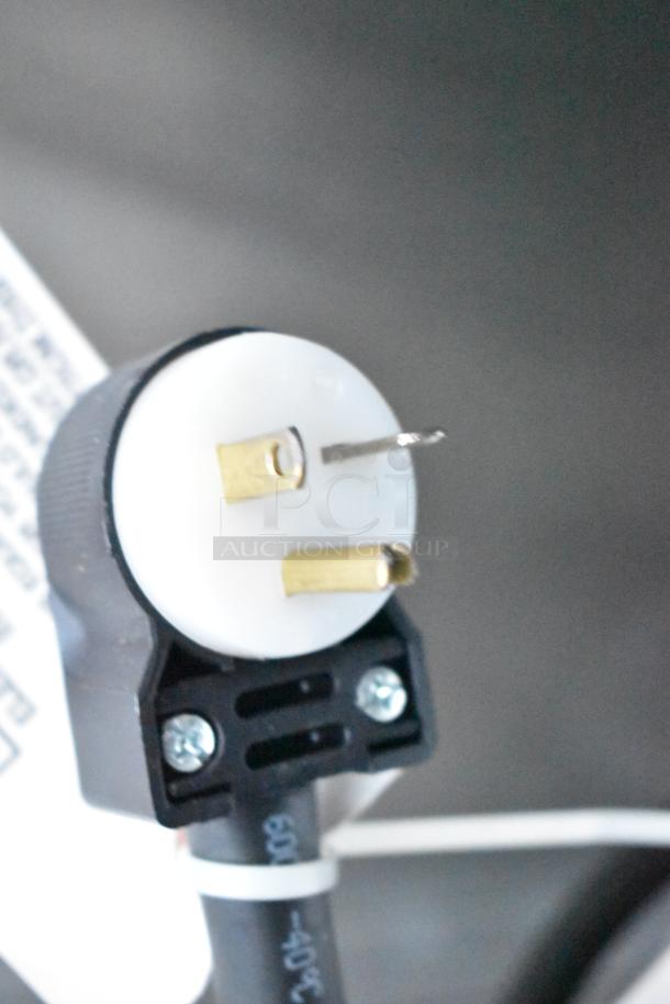 Close-up of an electrical plug with three prongs, featuring a white and black design. Suitable for high-power appliances.