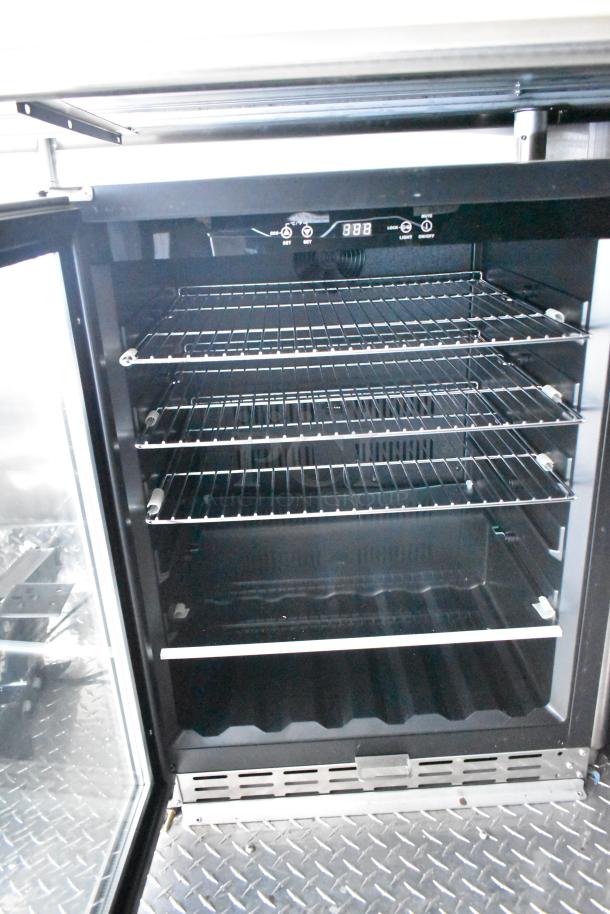 Rock Solid Cargo fast-food trailer refrigerator interior with metal racks and digital controls, showcasing clean condition.