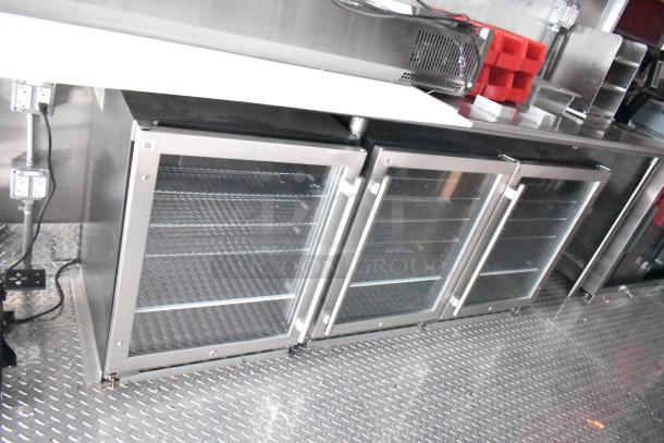Rock Solid Cargo fast food trailer interior with glass door refrigeration units, commercial-grade stainless steel surfaces, and power outlets.