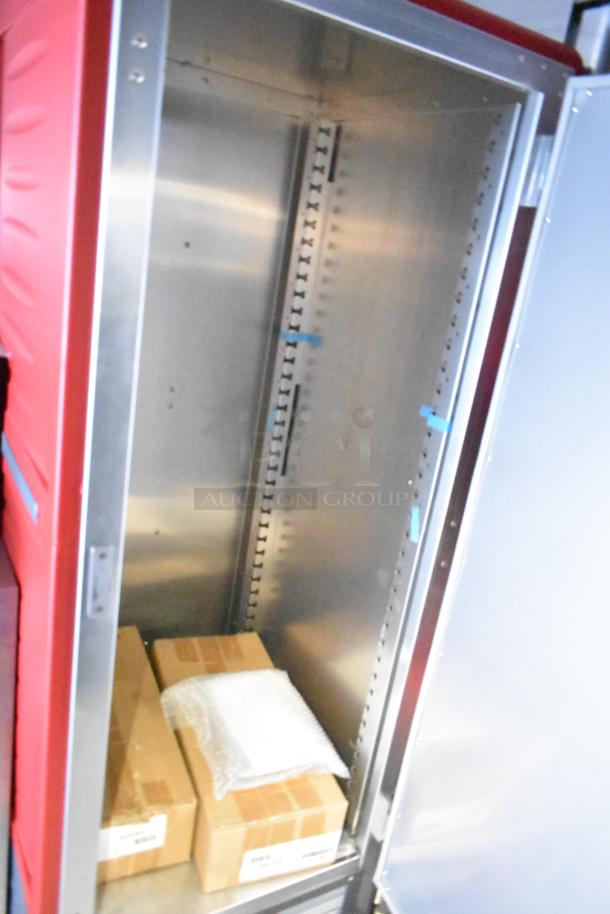 Interior of Rock Solid Cargo fast food trailer, featuring empty stainless steel shelving with some packaged items below.