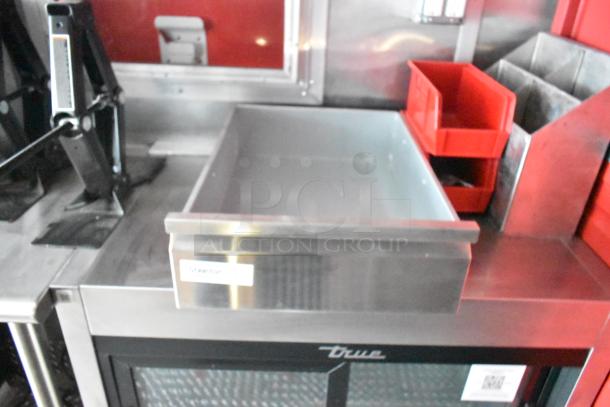 Rock Solid Cargo mobile kitchen interior with stainless steel counter, storage bins, and "True" refrigeration unit visible.