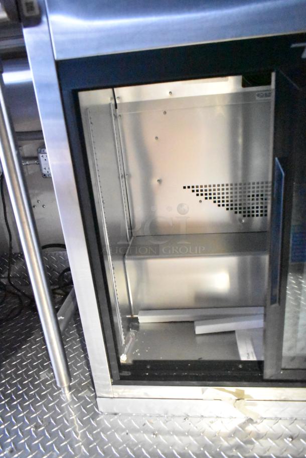 Interior view of Rock Solid Cargo mobile kitchen trailer, featuring stainless steel commercial-grade systems and fixtures.