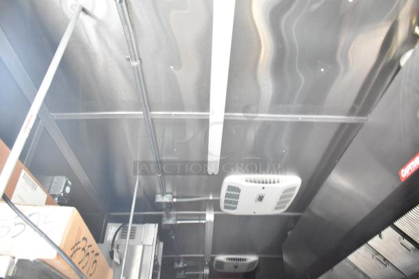 Interior view of a Rock Solid Cargo fast food trailer featuring ceiling fixtures, ductwork, and visible CaptiveAire grease hood.