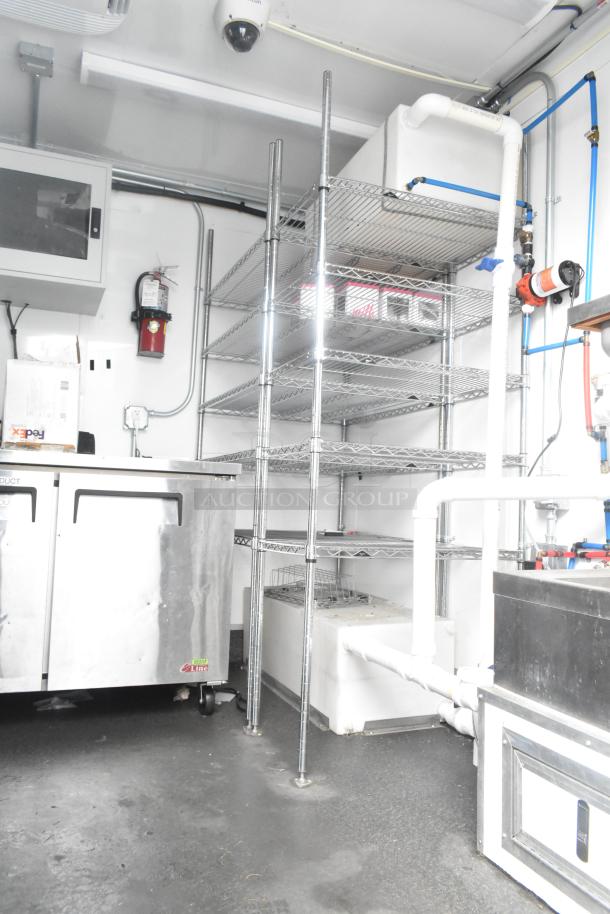 Fully outfitted 24' Southern Dimensions trailer with commercial refrigeration, wire shelving, and plumbing. Ideal for food service.