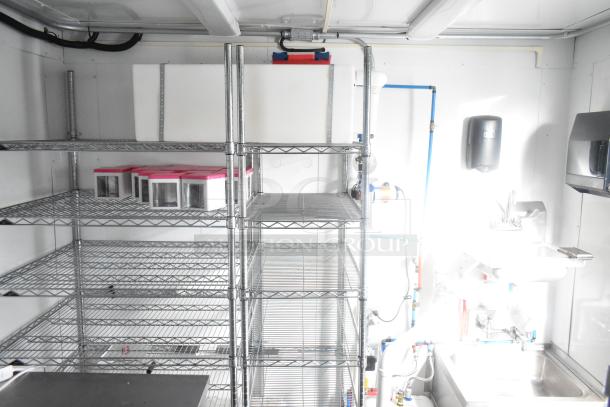 Southern Dimensions 24' cold food trailer interior with wire shelving, sinks, and commercial-grade equipment. New condition.
