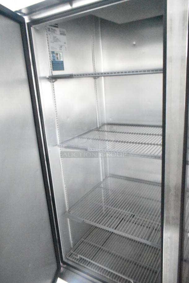 Interior of a commercial-grade True reach-in cooler with wire shelving inside a Southern Dimensions 24' retail trailer.