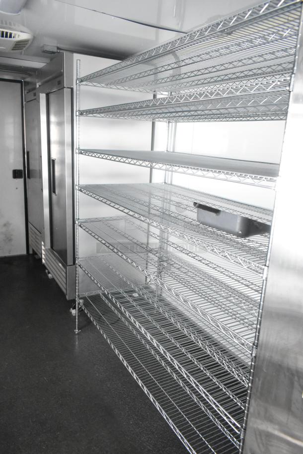 Southern Dimensions 24' trailer interior with wire shelving and reach-in coolers. Fully equipped for food/beverage service.