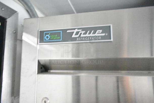 True refrigerator in Southern Dimensions 24' trailer. Features stainless steel finish, labeled "natural refrigeration."