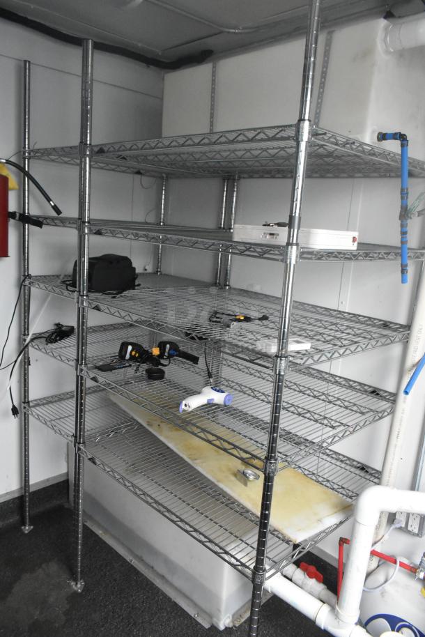Stainless steel wire shelving units in a Southern Dimensions 24' trailer, equipped with plumbing fixtures, ready for retail use.