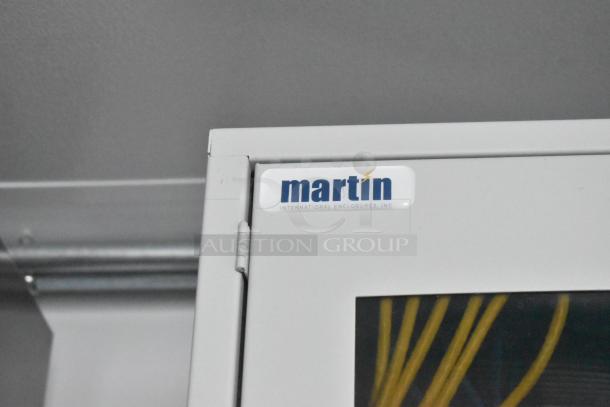 Gray cabinet with a "Martin International Enclosures, Inc." label on the top corner, indicating brand.