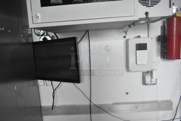 Interior of Southern Dimensions 24' trailer, showing mounted monitor, control panel, and fire extinguisher on white wall.