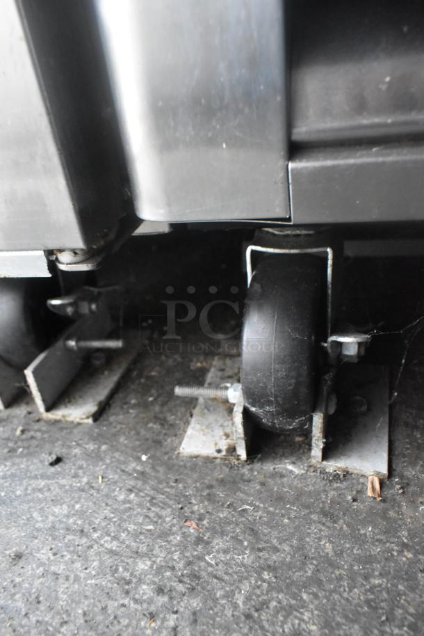 Caster wheel detail on Southern Dimensions 24' cold food trailer. Metal frame, secure bolts. Rugged, ready for setup.