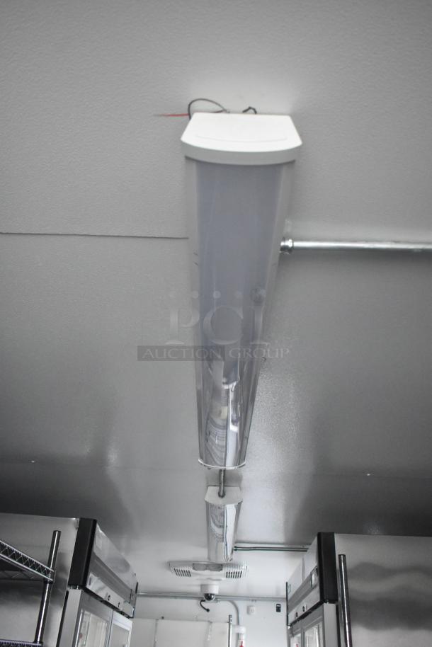 Interior of Southern Dimensions 24' cold food trailer, featuring commercial-grade lighting, seen from below.