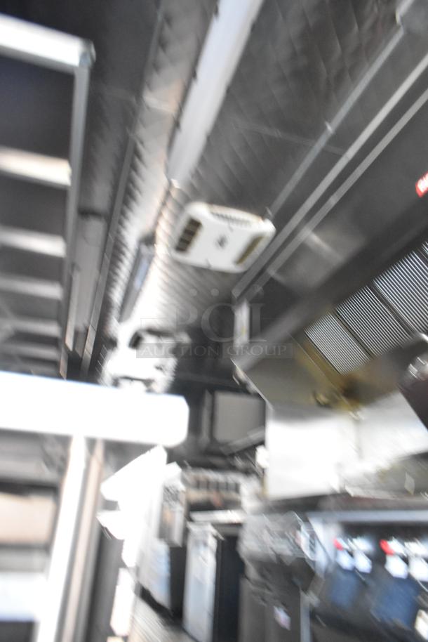 Interior of a fully equipped 2021 Wendy's fast food trailer with commercial kitchen appliances, including a grease hood and coolers.