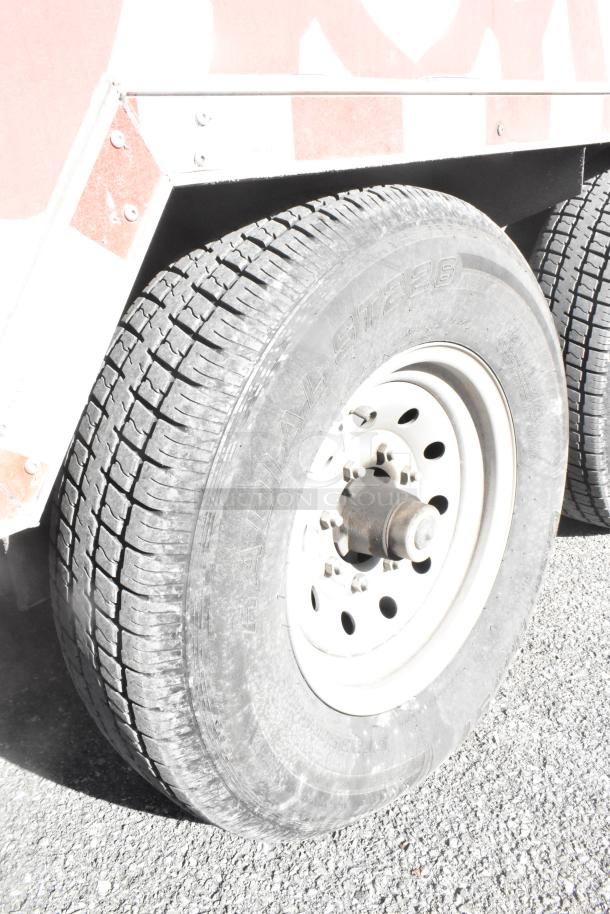 Close-up of the tire on a 28' Wendy's mobile kitchen trailer. Features a durable tread. Ready for operation.