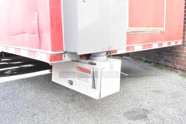 Red 28' Wendy's fast food trailer hitch. Visible warning label and green wiring. ajar panel. Weathered condition.
