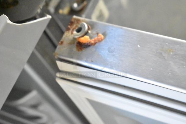 Close-up of a metal component with rust and residue on a 28' Wendy's fast food trailer door frame, shows minor wear.