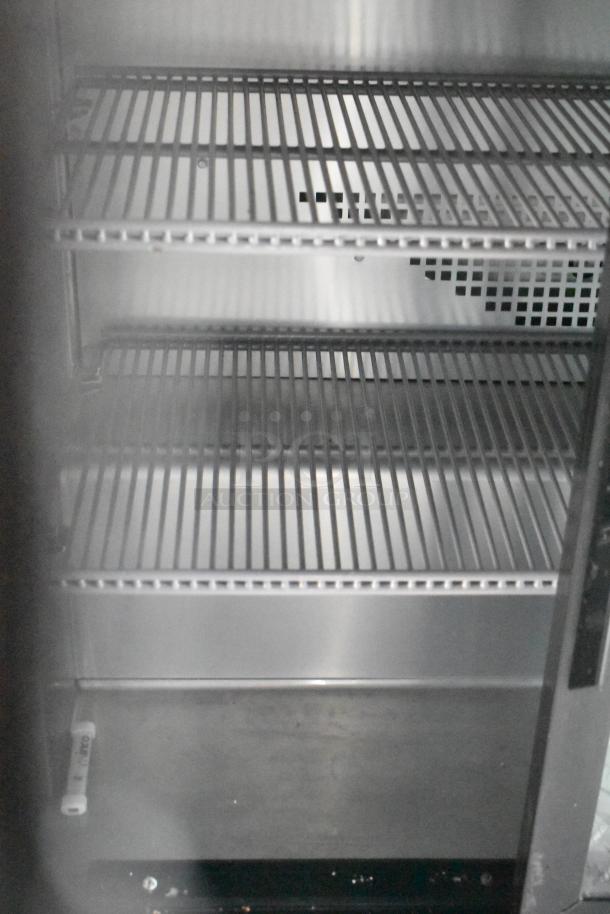 Interior view of commercial-grade cooler with metal racks in a fast food trailer; clean and ready for use.