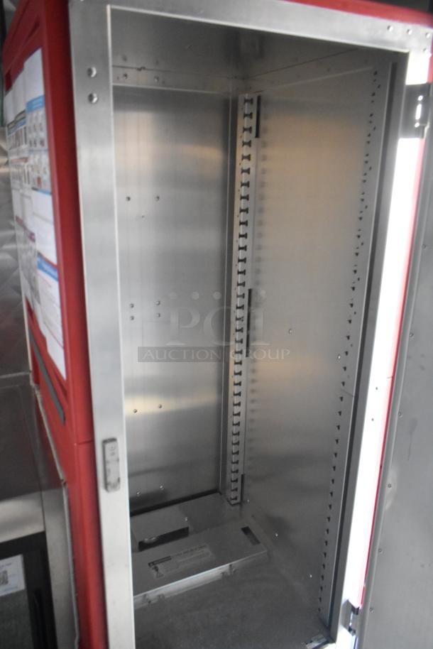 Empty stainless steel interior compartment of a 28' fast food trailer. Shelving tracks visible. Clean and spacious.