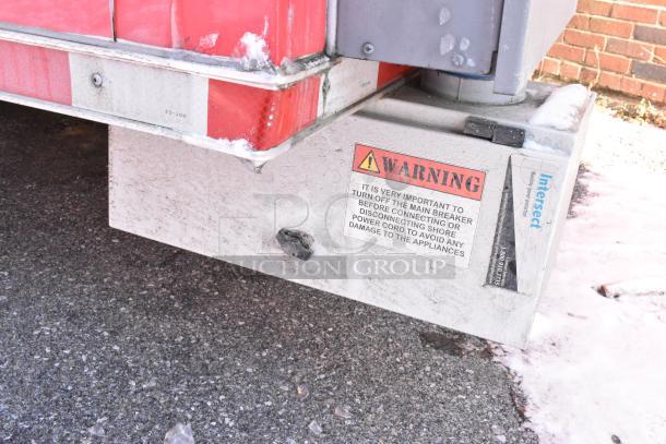 Close-up of a Wendy's fast food trailer warning label on the metal exterior. Visible snow and road surface.